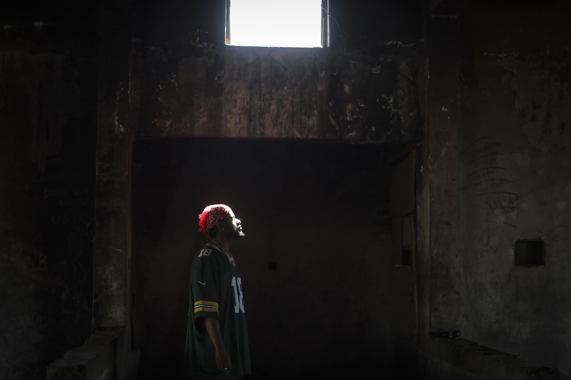 Kamal looks up at a window of light in a dark cell, from Bufis – Daydreamers