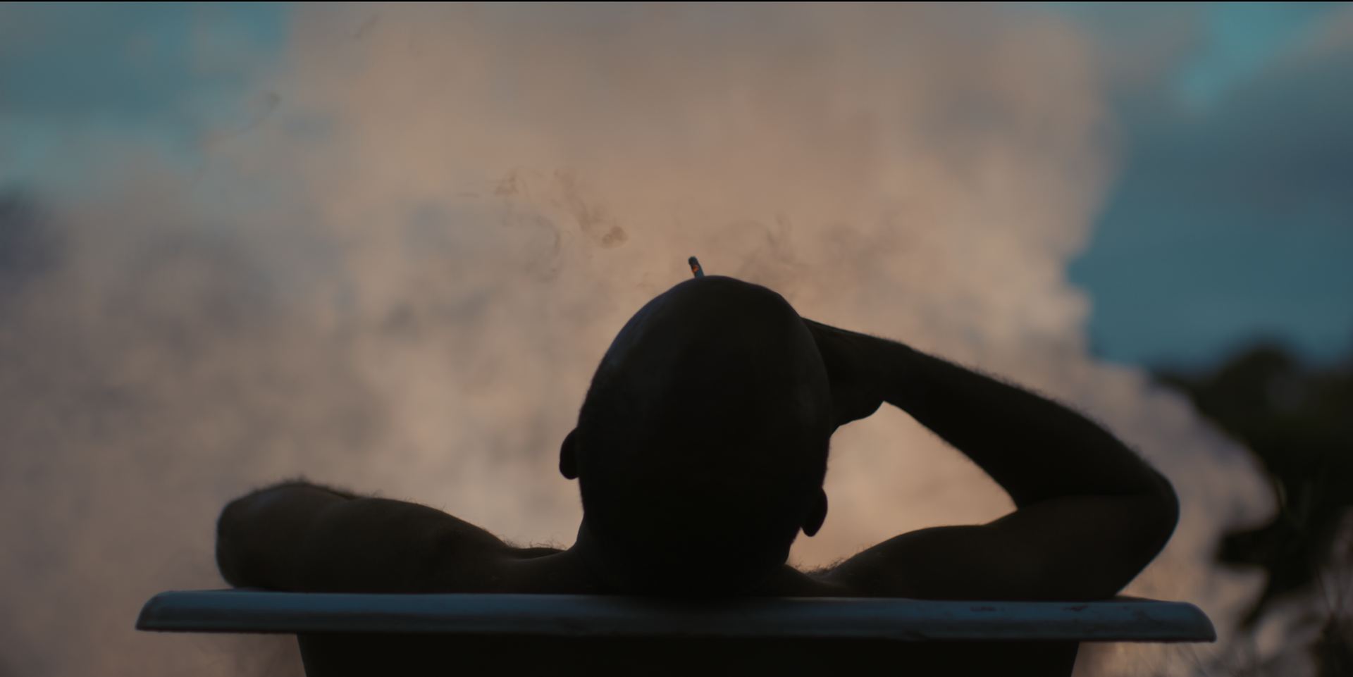 A man in a bathtub seen from behind against the clouds, from Bufis – Daydreamers